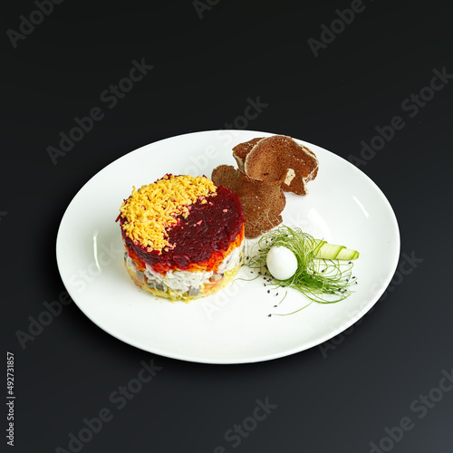 traditional dishes of European cuisine, delicacy, banquet snack. culinary dishes on a white plate on a black background. restaurant service photo