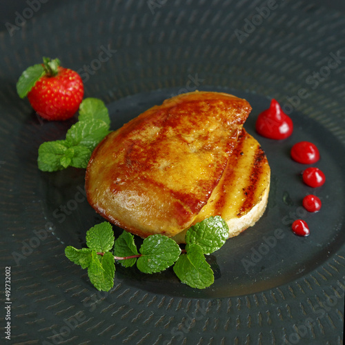 traditional dishes of European cuisine, delicacy, banquet snack. culinary dishes on a white plate on a black background. restaurant service photo