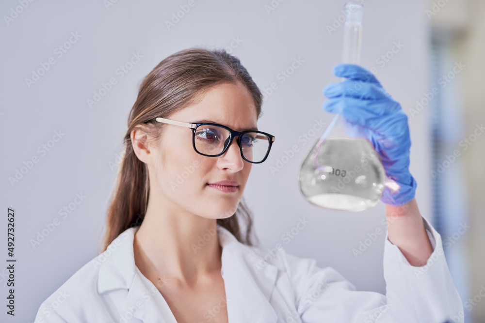 Making new discoveries. Shot of a scientist examining a beaker of liquid while standing in a laboratory. Making new discoveries. Shot of a scientist examining a beaker of liquid while standing in a laboratory.