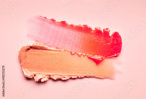 Lipstick burgundy peach orange brown balm lip gloss swatch isolated on beige background