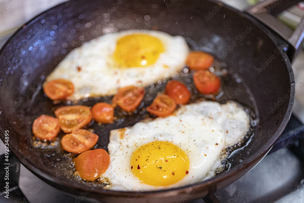 scrambled eggs with spices and small red tomatoes
