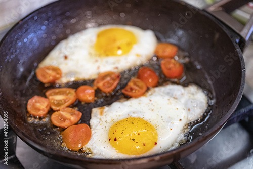 scrambled eggs with spices and small red tomatoes