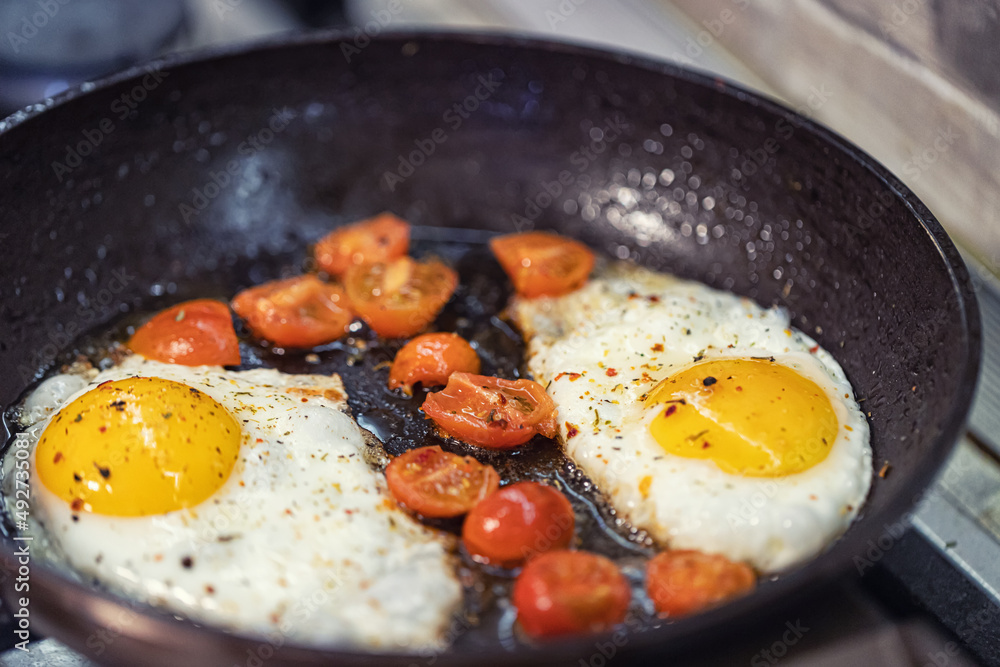 scrambled eggs with spices and small red tomatoes scrambled eggs with spices and small red tomatoes
