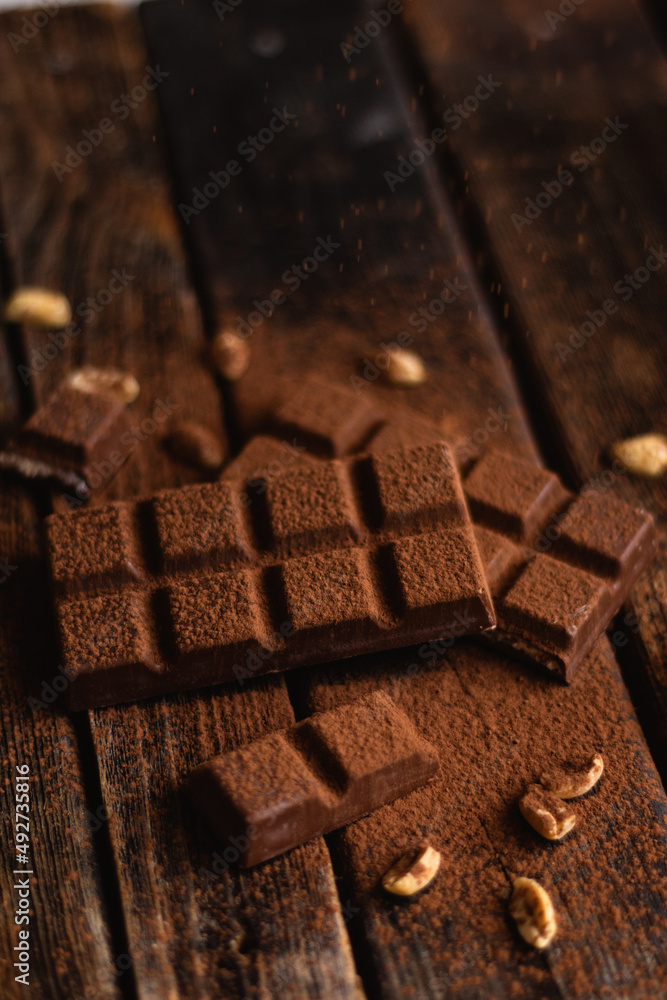 Bar of chocolate on a dark background. Cocoa and nuts. Bar of chocolate on a dark background. Cocoa and nuts.
