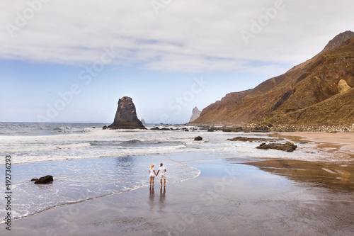 A couple walks on the Sandy beach of Benijo on the island of Tenerife.The Canary Islands. Spain photo