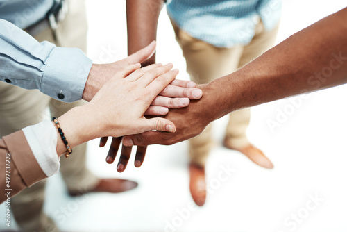 Lets do it together or not at all. Cropped shot of colleagues joining their hands together in unity.