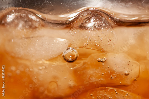 Bubbles air in carbonated beverages with iced, macro shot.