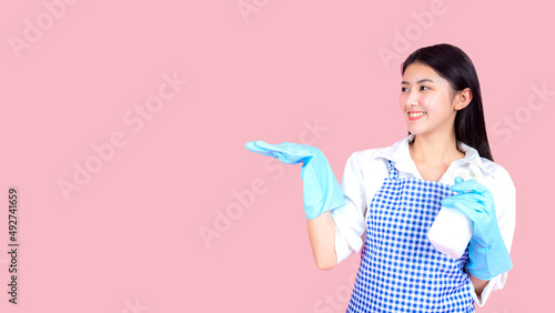 Portrait asian beautiful woman wearing apron and rubber gloves for cleaning   Housekeeper standing with products and equipment cleaner.
