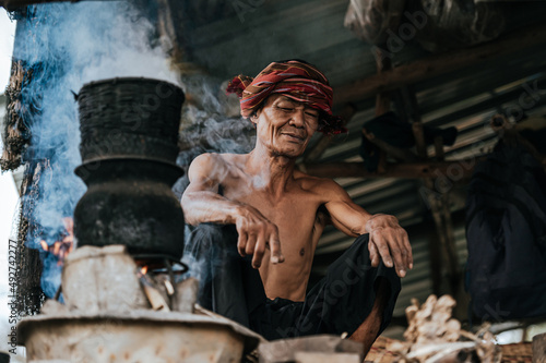 Wallpaper Mural Senior man steaming sticky rice with wood stove lifestyle in countryside Torontodigital.ca