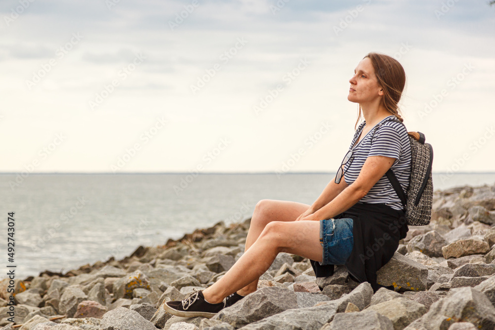 Beautiful girl on the sea with blue sky and clouds