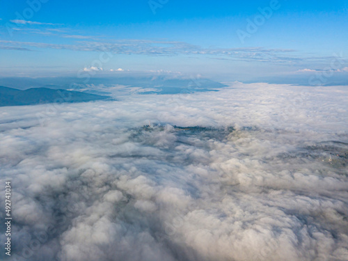 High flight above the clouds in the mountains. Aerial drone view.