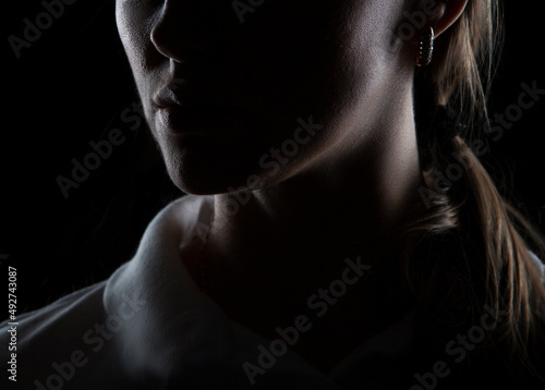 Close-up part of face silhouette with lips and neck of young woman. Isolated on black background © beauty_objects