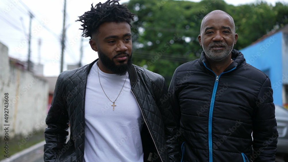 Father and son walking together bonding talk Father and son walking together bonding talk