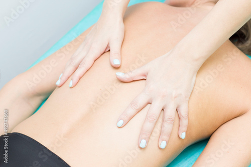 A relaxed woman receiving a back massage at a wellness center.