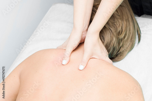 A relaxed woman getting a neck massage at a wellness center