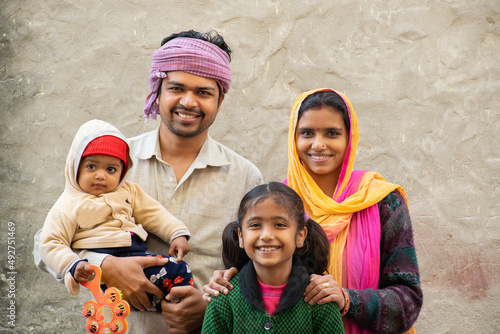 smiling Indian rural family, parents tanding with their children photo
