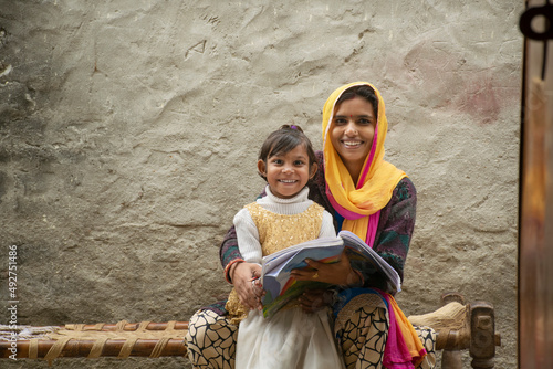 happy indian mother and daughter, mother helping her daughter in study photo
