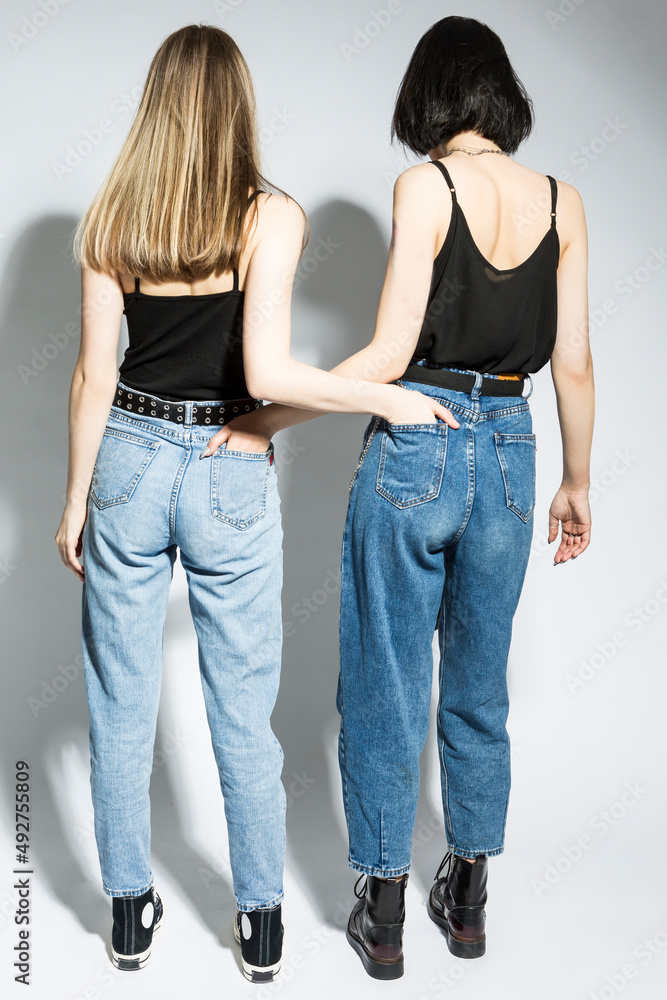 Youth Lifestyle Concepts. Full Length Portrait of Young Caucasian Lesbian  Couple Standing While Hands in Pockets Jeans Of Each Other Over White  Background Stock Photo | Adobe Stock