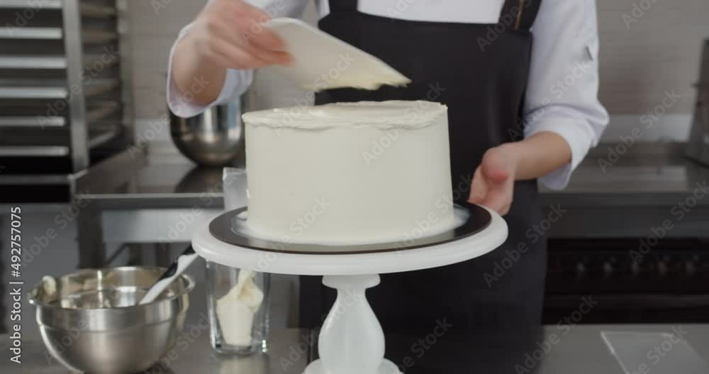 Professional confectioner decorates a holiday cake in the confectionery shop Professional confectioner decorates a holiday cake in the confectionery shop