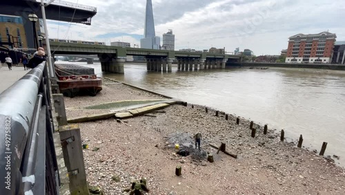 Mudlarks, London. A mudlark is someone who scavenges in river mud for items of value, a term used especially to describe those who scavenged this way in London during the late 18th and 19th centuries. photo