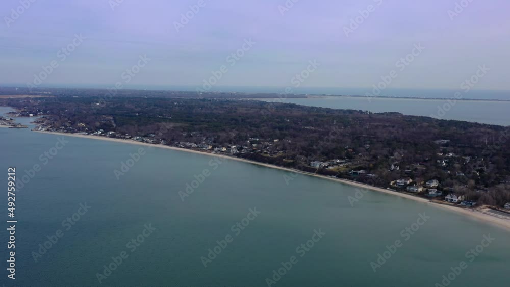A high angle view over Peconic River looking at Meschutt Beach on Long Island, NY. The camera truck right, high enough to see Shinnecock Bay and the Atlantic Ocean. It is a hazy day. A high angle view over Peconic River looking at Meschutt Beach on Long Island, NY. The camera truck right, high enough to see Shinnecock Bay and the Atlantic Ocean. It is a hazy day.