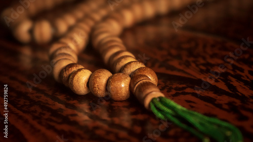 Islamic prayer beads or tasbih hung on the edge of the Quran book stand in an artistic rural room. It is suitable for background of Ramadan-themed design concepts, selected focus photo