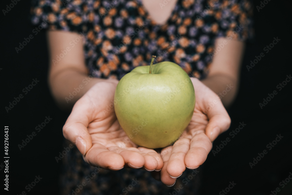 green apple in hands of woman