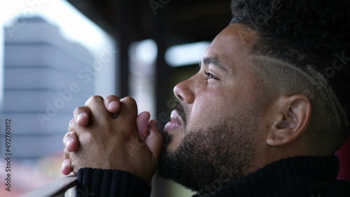 Young man opening eyes to sky having HOPE and FAITH while praying to GOD