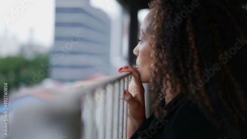 фотографія Woman peeking outside from balcony looking out staring out