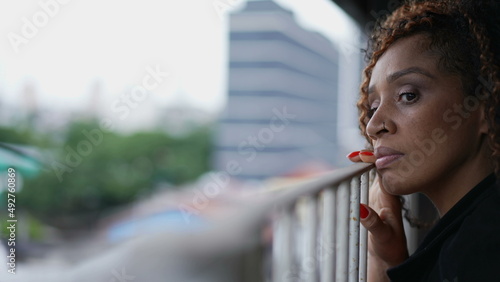 Woman peeking outside from balcony looking out staring out