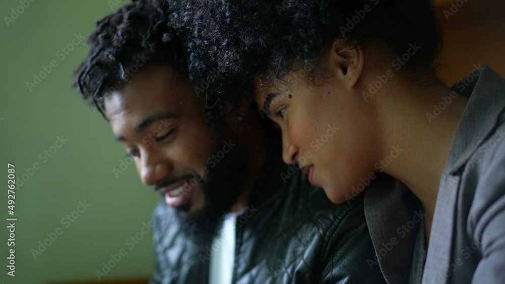 Naklejka premium A black couple laughing and smiling in conversation candid and casual