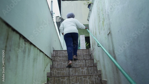 older woman going up the stairs at home arriving house © Marco