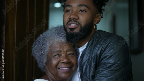 Adult grandson embracing senior grandmother authentic and real life