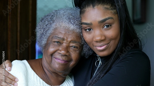 A teen granddaughter embracing grandmother a black girl embraces grandparent