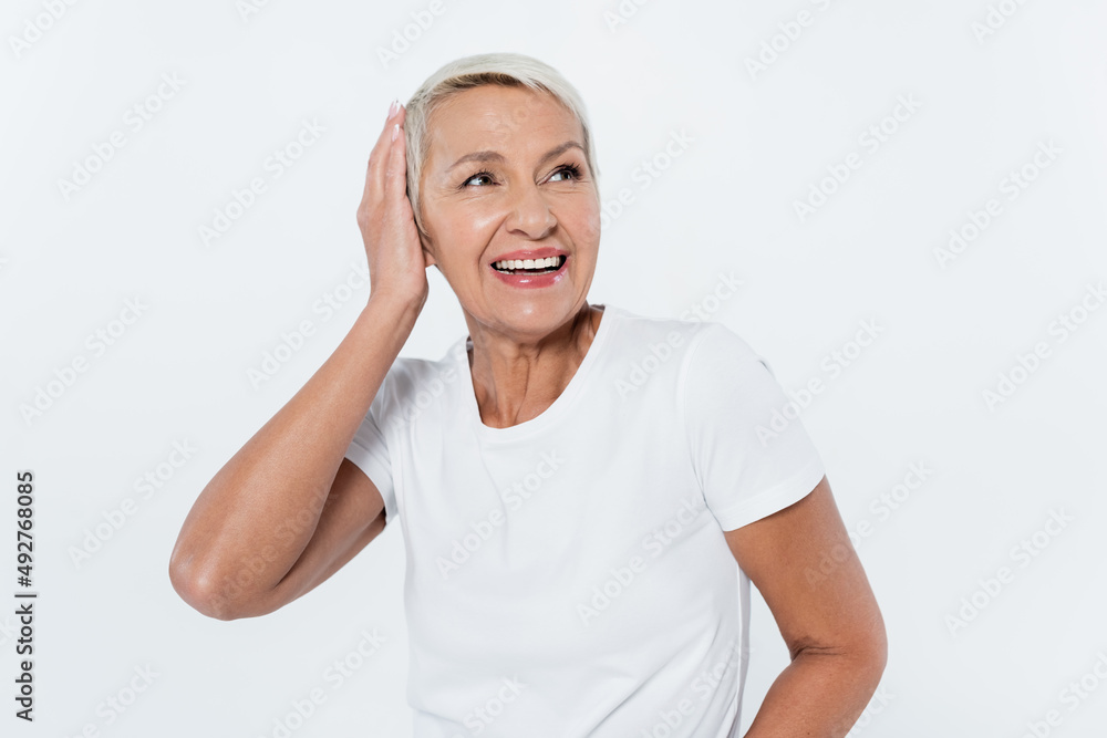 Happy senior woman touching head isolated on grey. Happy senior woman touching head isolated on grey.