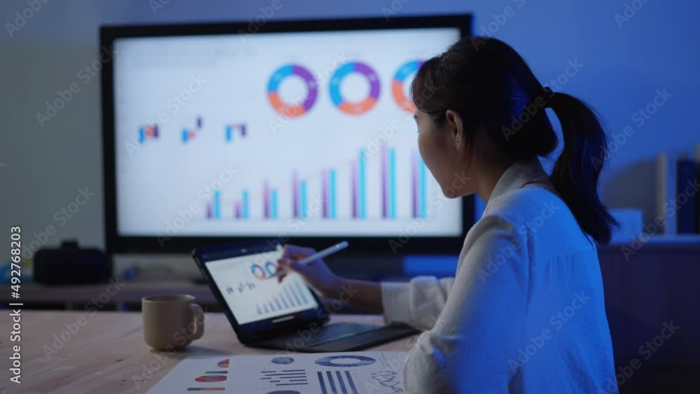 Young adult Asian businesswoman work with computer laptop for finance of business. woman with online learning with marketing class at night at home Young adult Asian businesswoman work with computer laptop for finance of business. woman with online learning with marketing class at night at home