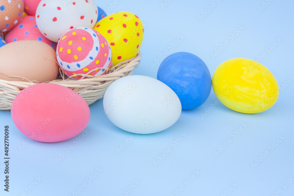 Colorful eggs in a basket on blue background	