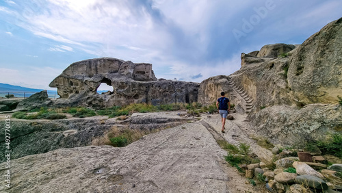 A male tourist exploring the ancient cave city of Uplistsikhe overlooking the Mtkvari river in the Shida Kartli Region of Georgia, Caucasus, Eastern Europe. Sightseeing, tourism, walking. Near Gori photo