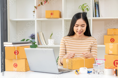 Startup Small Business Owners Female Entrepreneurs Work on receipt boxes and check online orders with your laptop to prepare the boxes. Selling to customers. Online SME business idea.