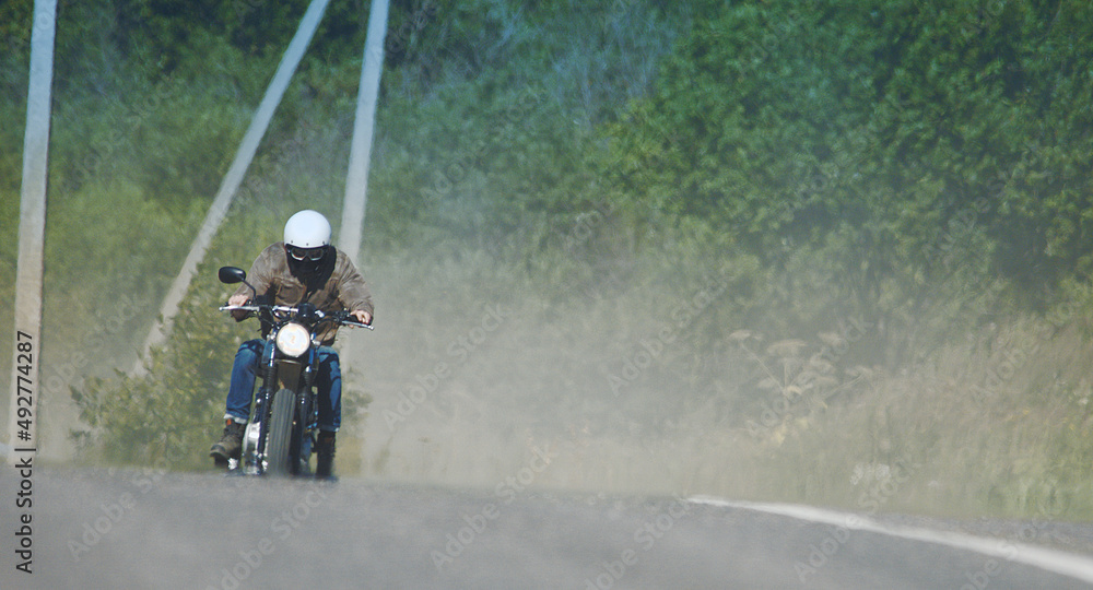 motorcyclist rides through a beautiful field motorcyclist rides through a beautiful field