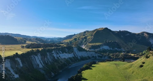 Flying around white cliffs over Rangitikei river lush fields - New Zealand photo