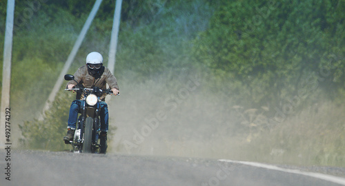 Fototapeta Naklejka Na Ścianę i Meble -  motorcyclist rides through a beautiful field