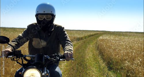 motorcyclist rides through a beautiful field