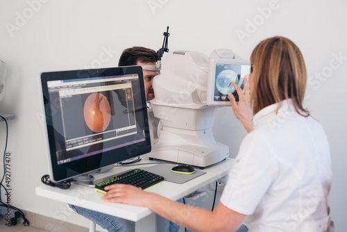 man patient has eye examination. digital retina scanner photo