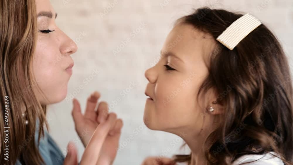 Happy cute affectionate adopted little kid girl hugging foster care parent mother with eyes closed, adorable small child daughter embrace mum cuddling enjoy tender sweet moment concept, close up view Happy cute affectionate adopted little kid girl hugging foster care parent mother with eyes closed, adorable small child daughter embrace mum cuddling enjoy tender sweet moment concept, close up view