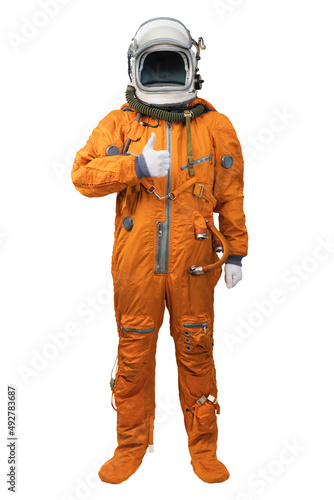 Astronaut wearing an orange spacesuit and helmet showing thumbs-up gesture isolated on white background. Cosmonaut with thumb up a hand against white background. Space for your copy