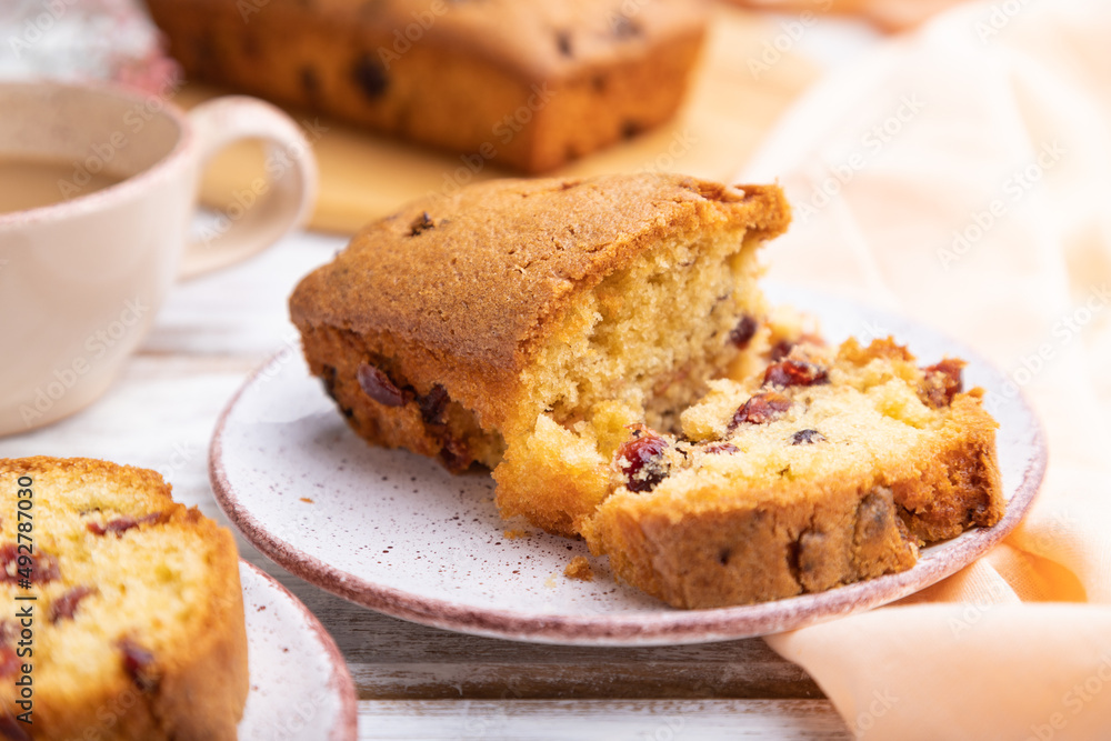 Homemade cake with raisins, almonds, soft caramel and a cup of coffee on a white wooden background. Side view, selective focus. Homemade cake with raisins, almonds, soft caramel and a cup of coffee on a white wooden background. Side view, selective focus.