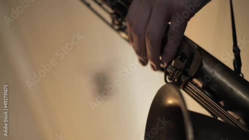 Saxofone, close up of hand playing music on a saxofone photo