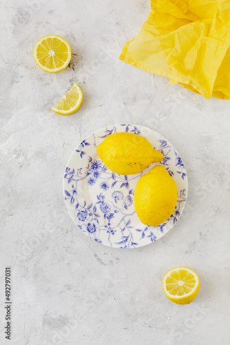Vintage plate with lemons on white background and yellow napkin