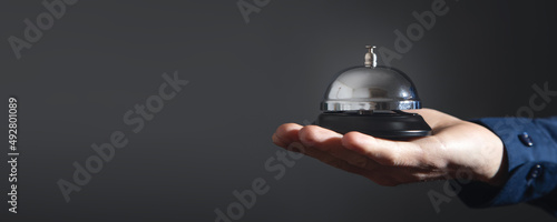 Male hand holding service bell at office.